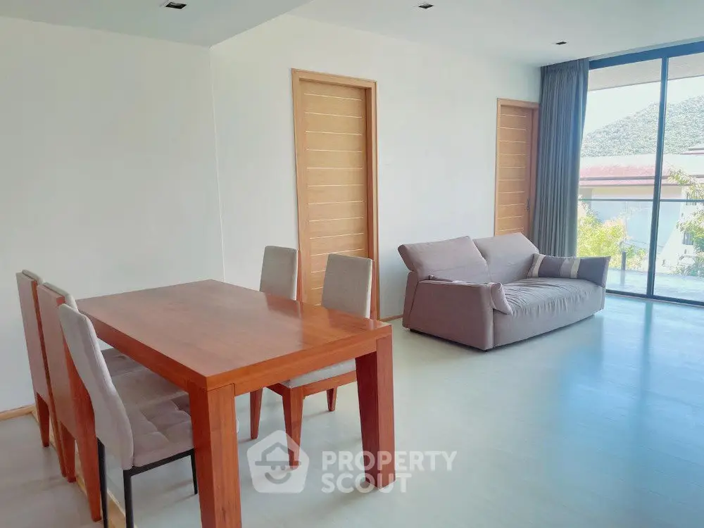 Spacious living room with modern furniture and large windows offering scenic views.