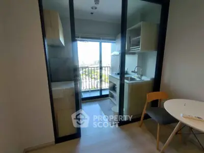 Modern compact kitchen with balcony view in urban apartment