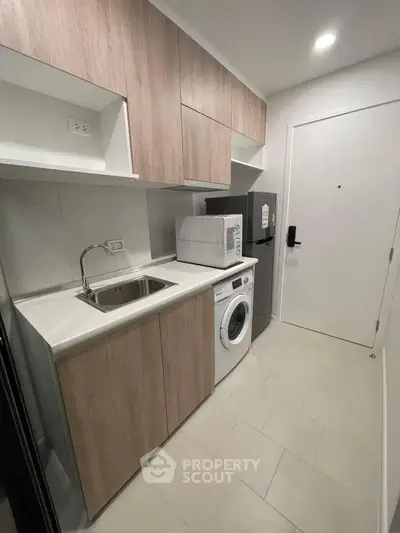 Modern compact kitchen with washing machine and sleek cabinetry