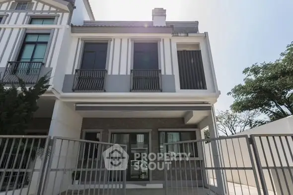 Modern townhouse exterior with gated entrance and large windows