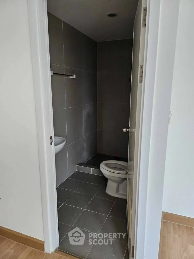 Compact bathroom with modern gray tiles and white fixtures
