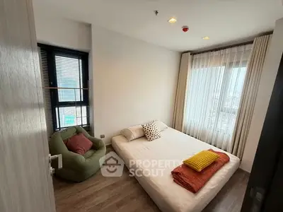 Cozy bedroom with large window and stylish decor in modern apartment.