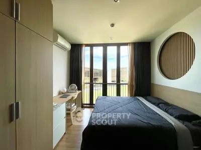 Modern bedroom with large window and stylish decor in a contemporary apartment.