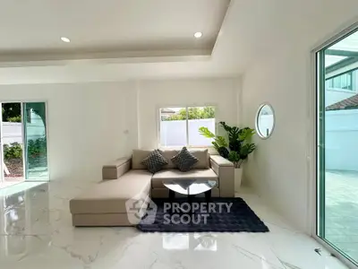 Spacious modern living room with elegant sofa and large windows