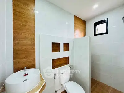 Modern bathroom with stylish wood accents and sleek white fixtures