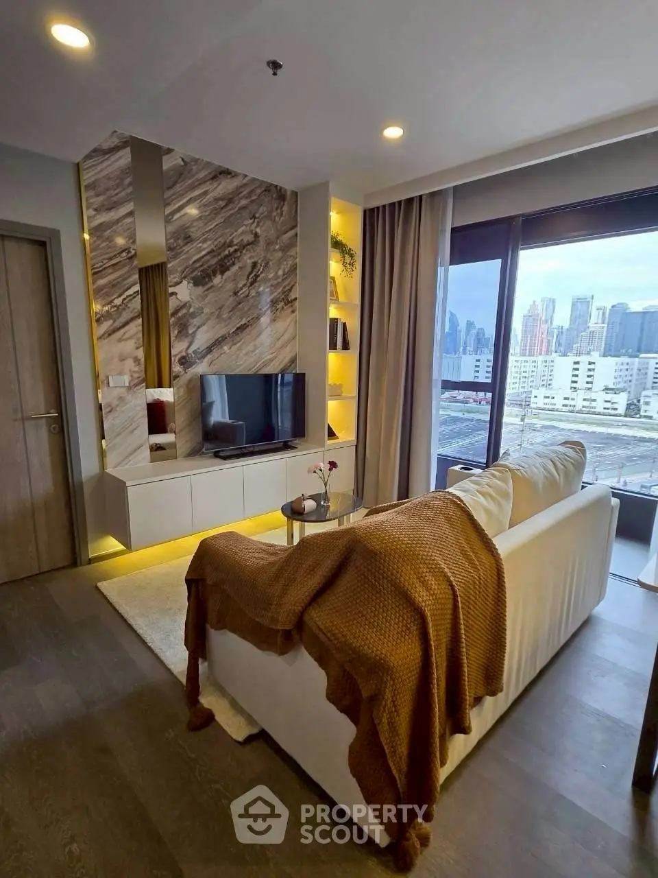 Modern living room with city view, stylish decor, and cozy ambiance.