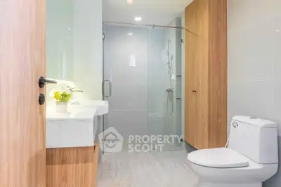 Modern bathroom with sleek design, glass shower, and wooden accents for a luxurious feel.