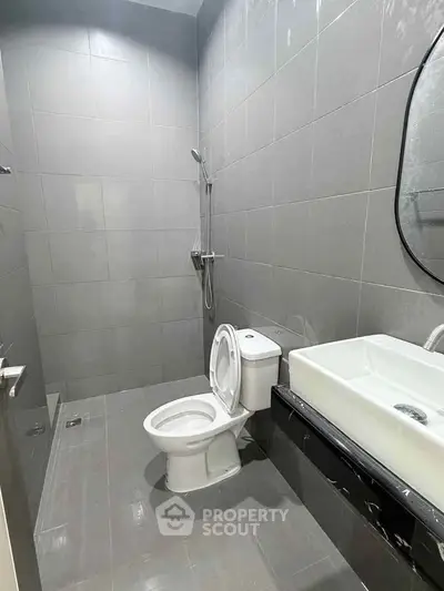 Modern bathroom with sleek gray tiles and contemporary fixtures.