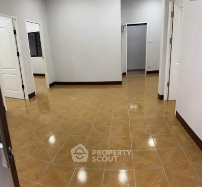 Spacious interior with tiled flooring and multiple doorways, ideal for versatile living arrangements.
