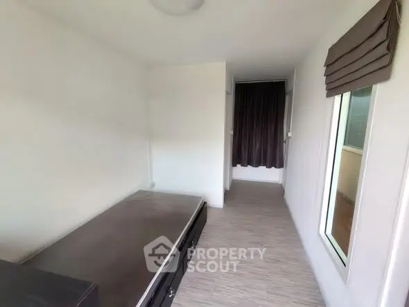 Compact bedroom with minimalist design and large window for natural light.