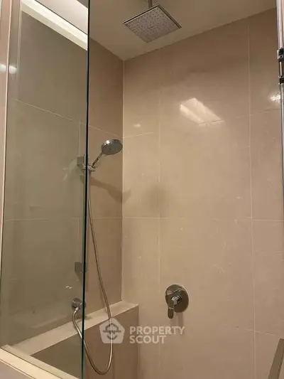 Modern bathroom with sleek shower and glass partition in luxury apartment.