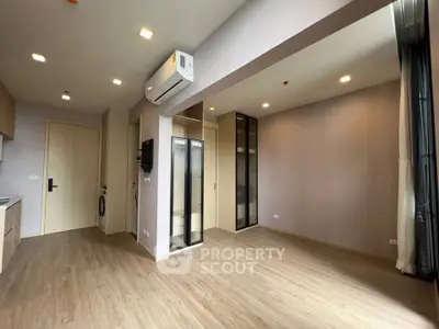Spacious modern living room with wooden flooring and built-in storage in a stylish apartment.