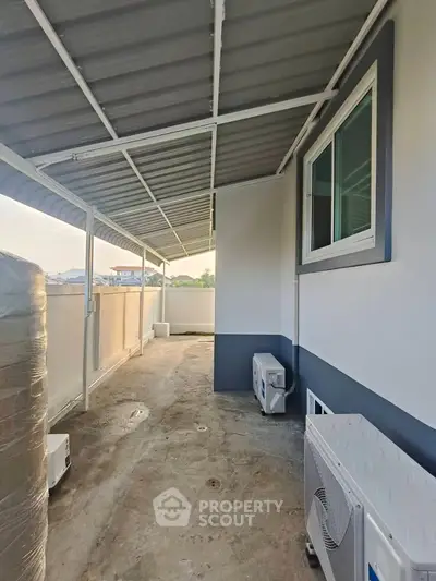 Spacious balcony with modern roofing and air conditioning units, perfect for relaxation.