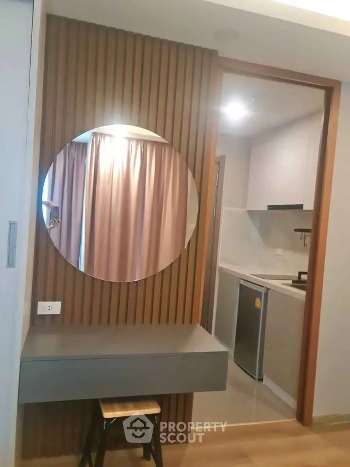 Modern apartment interior with stylish kitchen and round mirror accent.