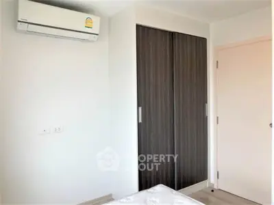 Modern bedroom with built-in wardrobe and air conditioning unit