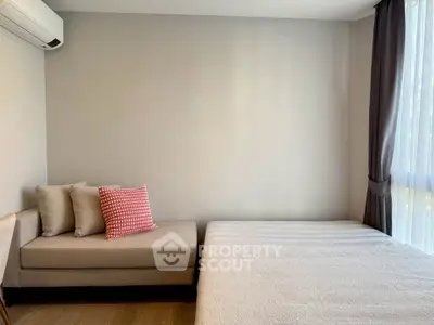 Modern bedroom with cozy sofa and large window for natural light