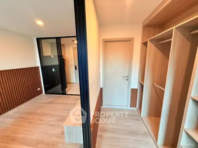 Modern bedroom with walk-in closet and wooden flooring, featuring sleek design and ample storage space.