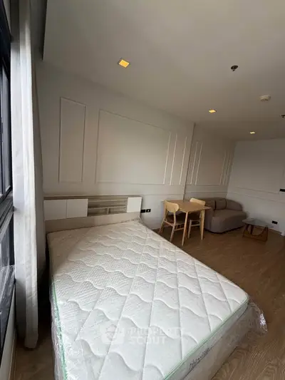 Modern bedroom with stylish decor and cozy seating area, perfect for urban living.
