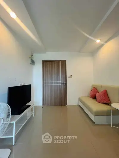 Modern living room with sleek design, featuring a comfortable sofa, flat-screen TV, and stylish lighting.