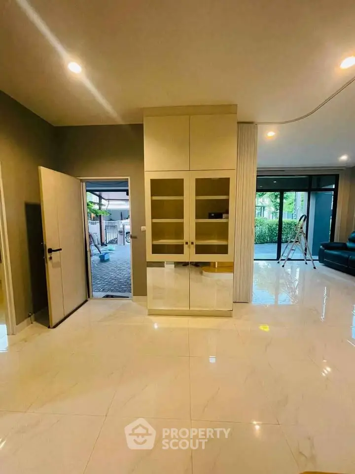 Spacious modern living room with glossy tile flooring and large windows for natural light.