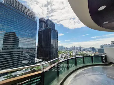 Stunning cityscape view from a modern high-rise balcony with sleek glass railing.