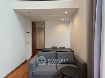Modern living room with sleek furniture and high ceiling in a contemporary apartment.