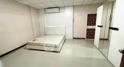 Spacious bedroom with minimalist design and air conditioning unit