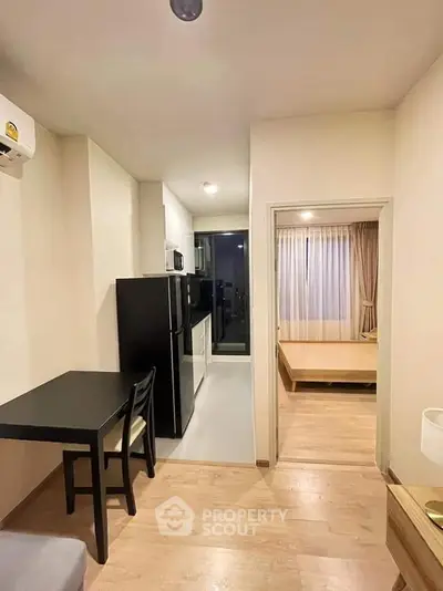 Modern apartment interior with compact kitchen and cozy bedroom