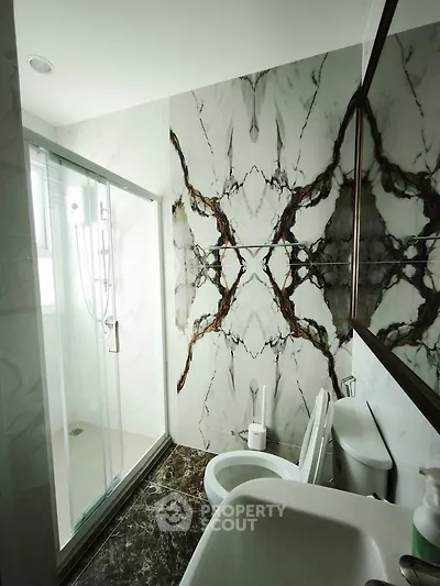 Luxurious bathroom with marble accents and modern shower enclosure