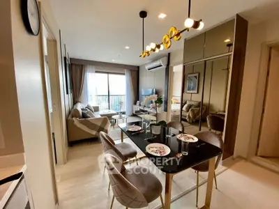 Modern living room with elegant dining area and large windows in a stylish apartment.
