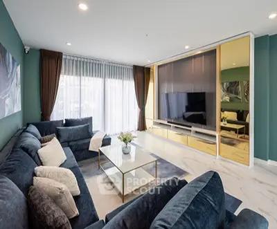 Luxurious modern living room with plush blue sofas, elegant decor, and large windows for natural light.