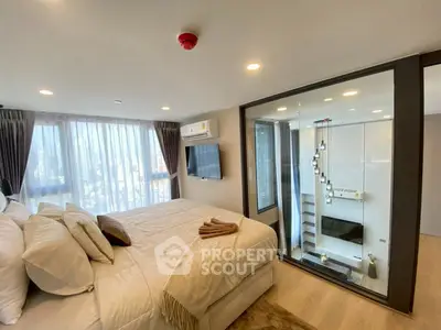 Luxurious bedroom with city view and modern glass-walled bathroom