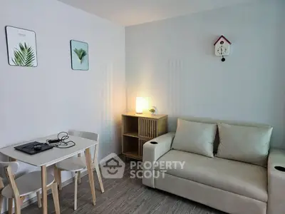 Cozy living room with modern decor, featuring a comfortable sofa and stylish dining area.