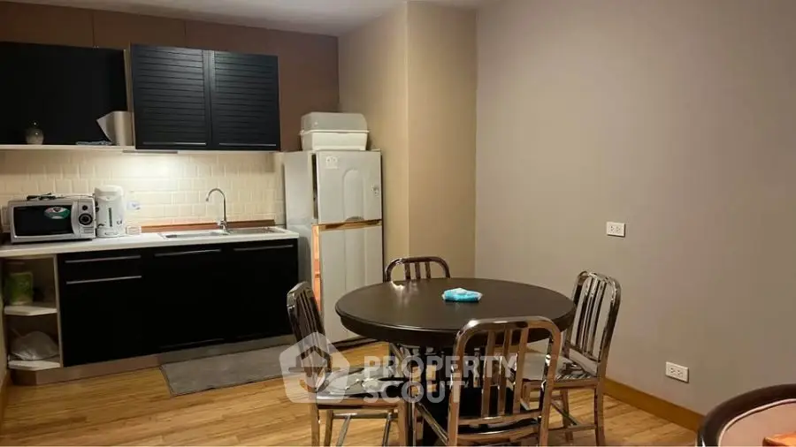 Cozy kitchen with dining area, featuring modern appliances and sleek cabinetry.