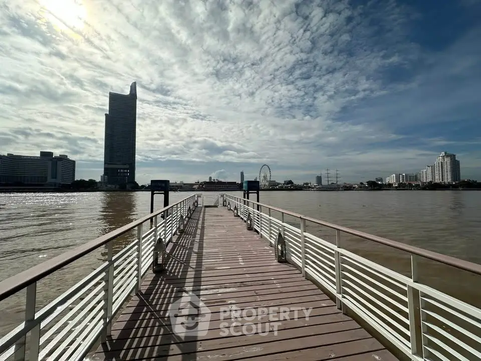 Stunning riverside view with modern skyscraper and ferris wheel in the background, perfect for urban living.