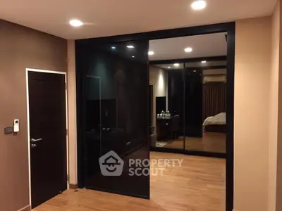 Modern bedroom with sleek glass sliding doors and warm wooden flooring