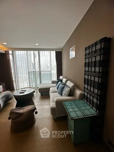 Stylish living room with modern furniture and large windows offering natural light.