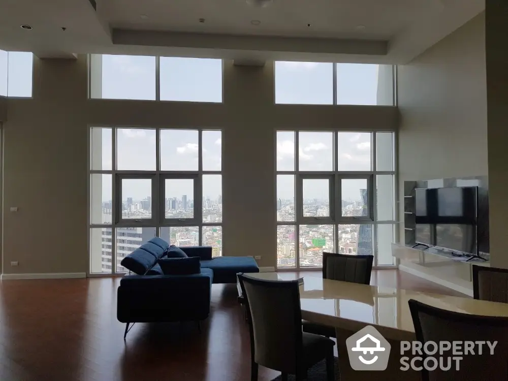 Spacious modern living room with panoramic city views and elegant furnishings.