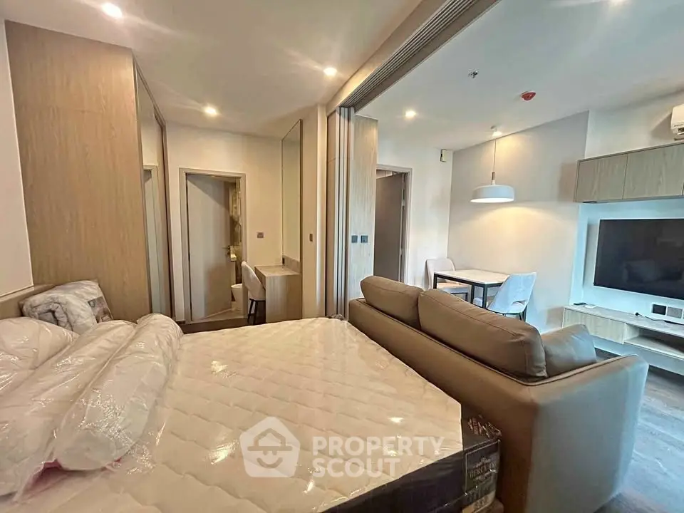 Modern studio apartment with open layout, featuring a cozy living area and stylish bedroom.