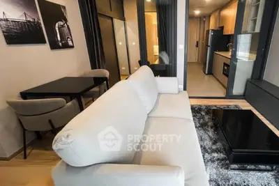 Modern living room with cozy sofa, dining area, and sleek kitchen in open layout apartment.