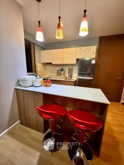 Modern kitchen with stylish red bar stools and sleek lighting