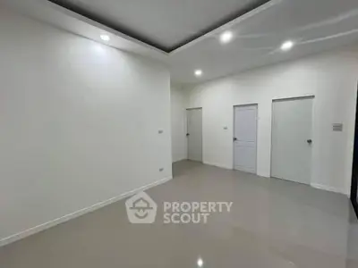 Spacious empty room with glossy floor and recessed lighting, ideal for customization.