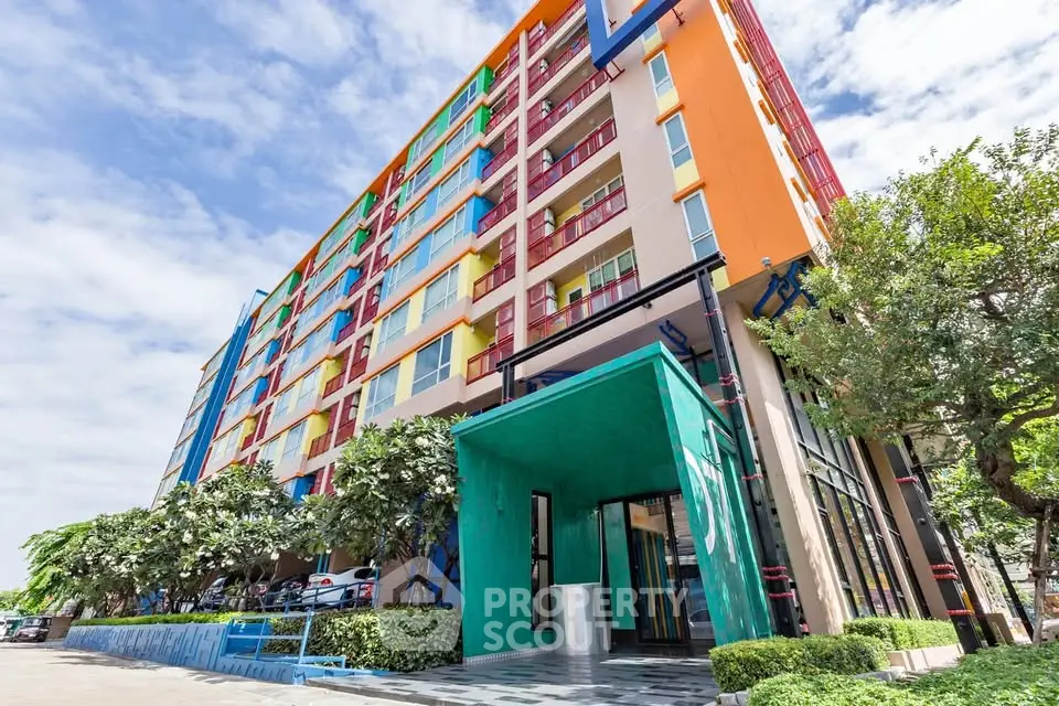 Vibrant modern apartment building with colorful facade and lush greenery, perfect for urban living.