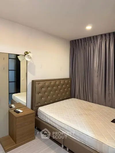 Modern bedroom with elegant tufted headboard and sleek bedside table in a cozy apartment.