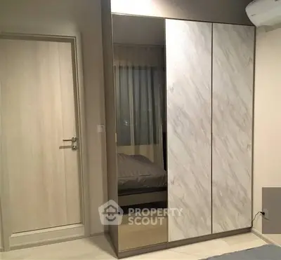 Modern bedroom with sleek wardrobe and air conditioning unit