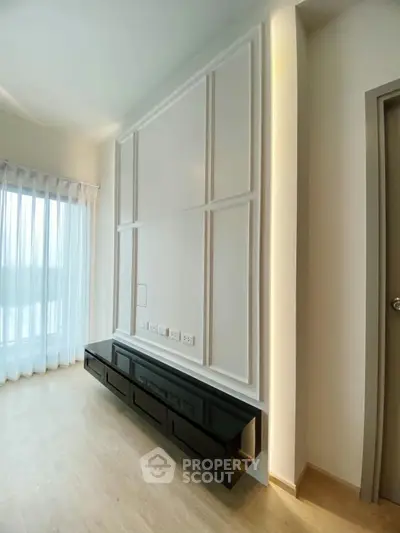 Modern living room with sleek black TV console and elegant wall paneling