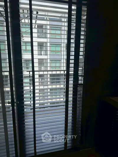 Modern apartment balcony with city view through stylish blinds.