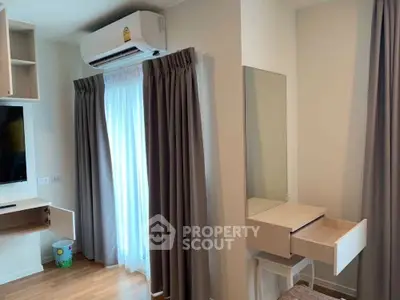 Modern bedroom with air conditioning and stylish vanity area, featuring elegant curtains and wooden flooring.