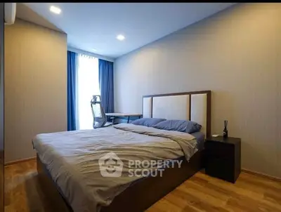 Modern bedroom with stylish decor and natural light, featuring a comfortable bed and work desk.