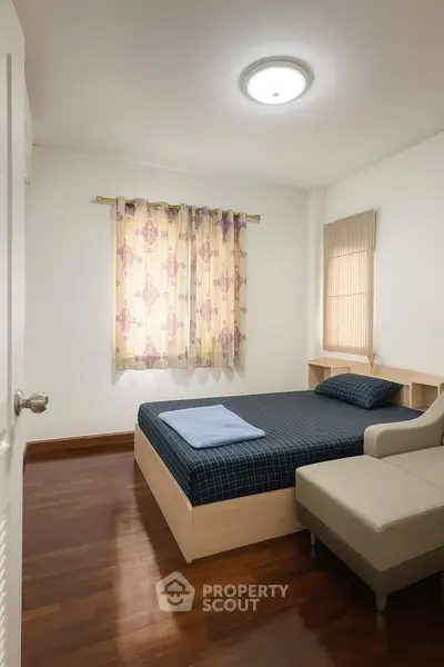 Cozy bedroom with wooden flooring and stylish curtains